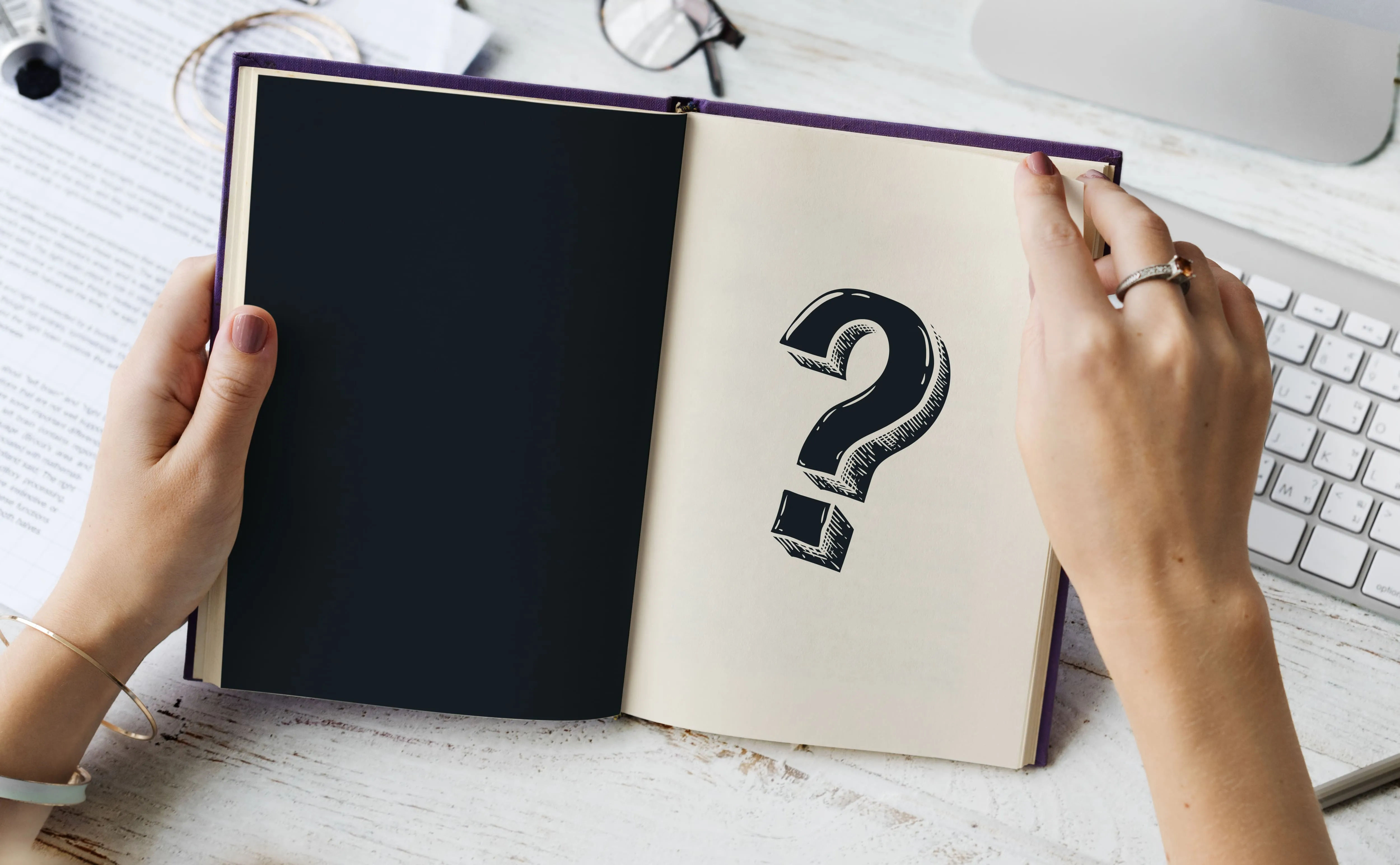 a man opens a book marked with a question mark